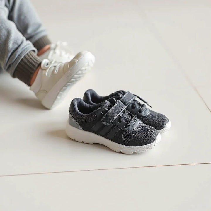 Sportskor för småbarn med flexibel sula och tydligt grepp på golv, bredvid sockade fötter