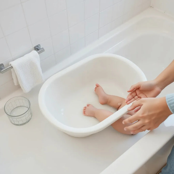 Rent babybadkar i ett ljust badrum med handtvätt och tillbehör för en trygg badstund