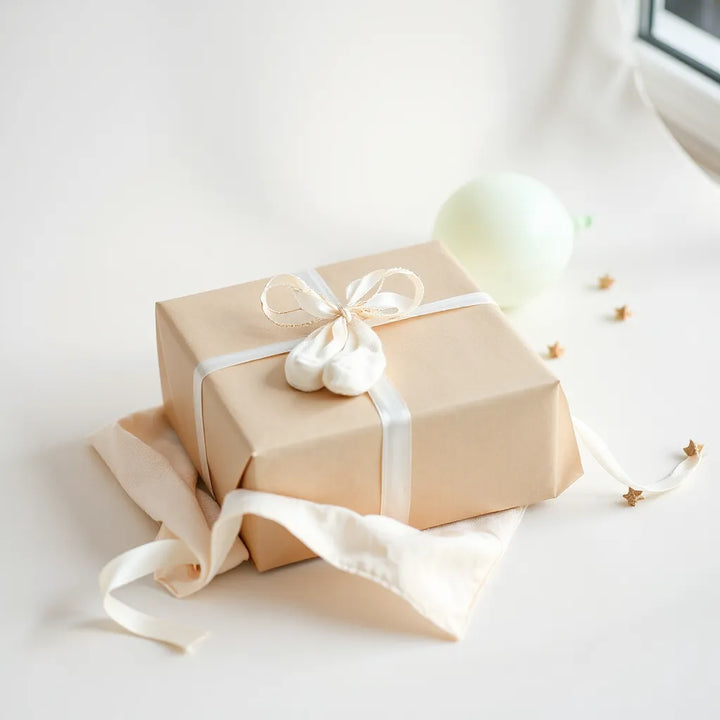 Inslagen babyshowerpresent med mjuka babysockor och filt på en ljus bakgrund