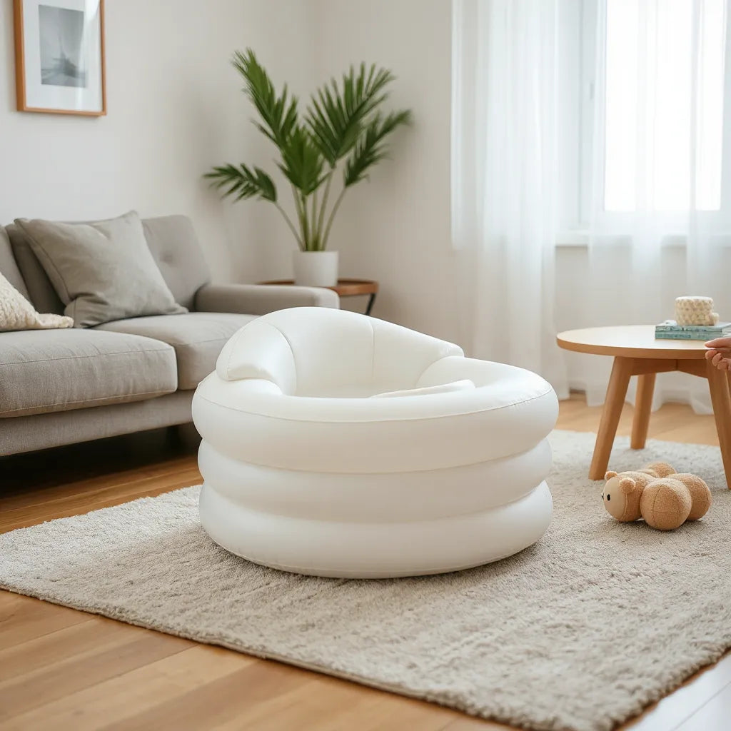Uppblåsbar babystol i vardagsrumsmiljö med mjuk sits och förälders hand som justerar positionen